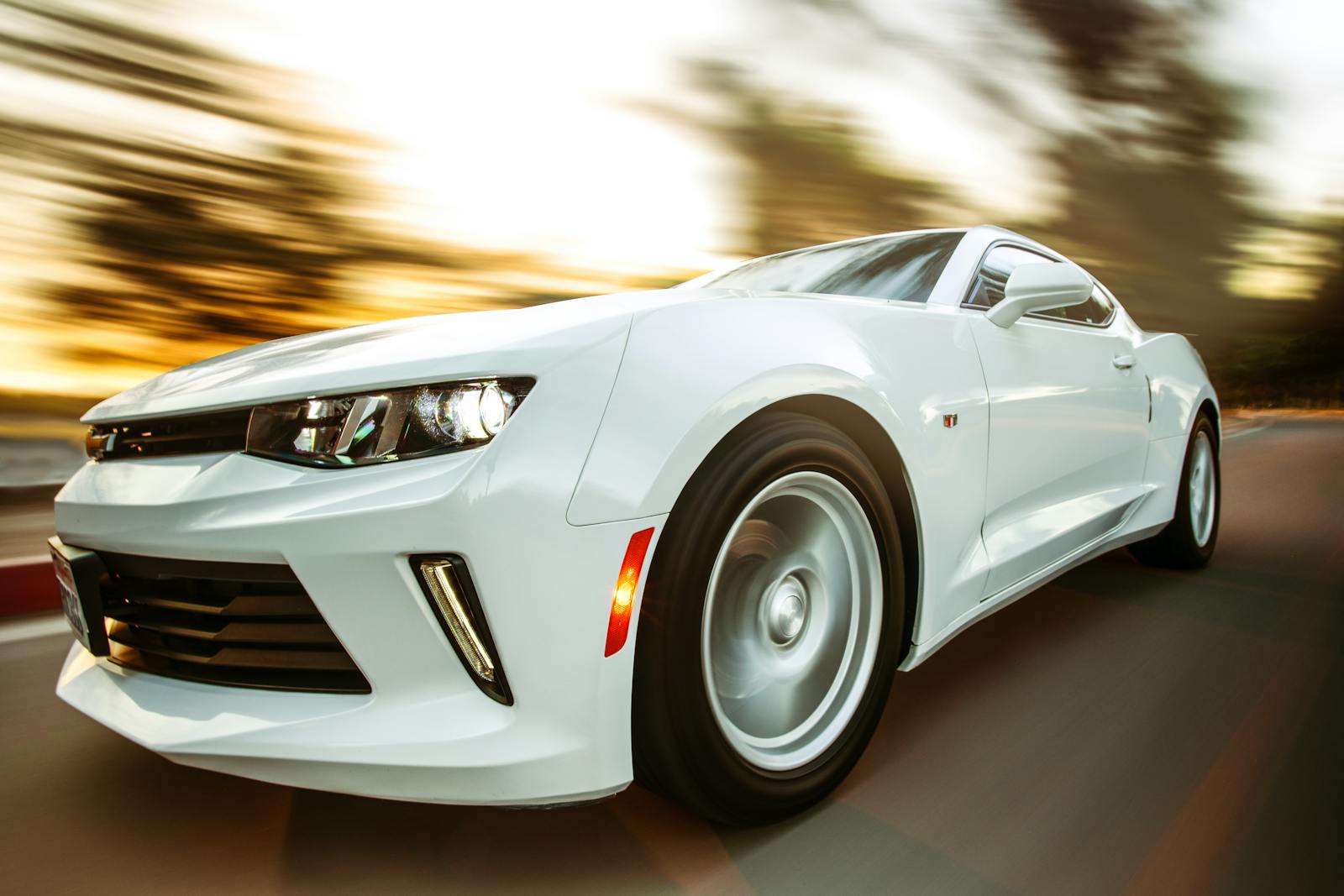 auto, white sportscar in motion showcasing speed and style on an open road.